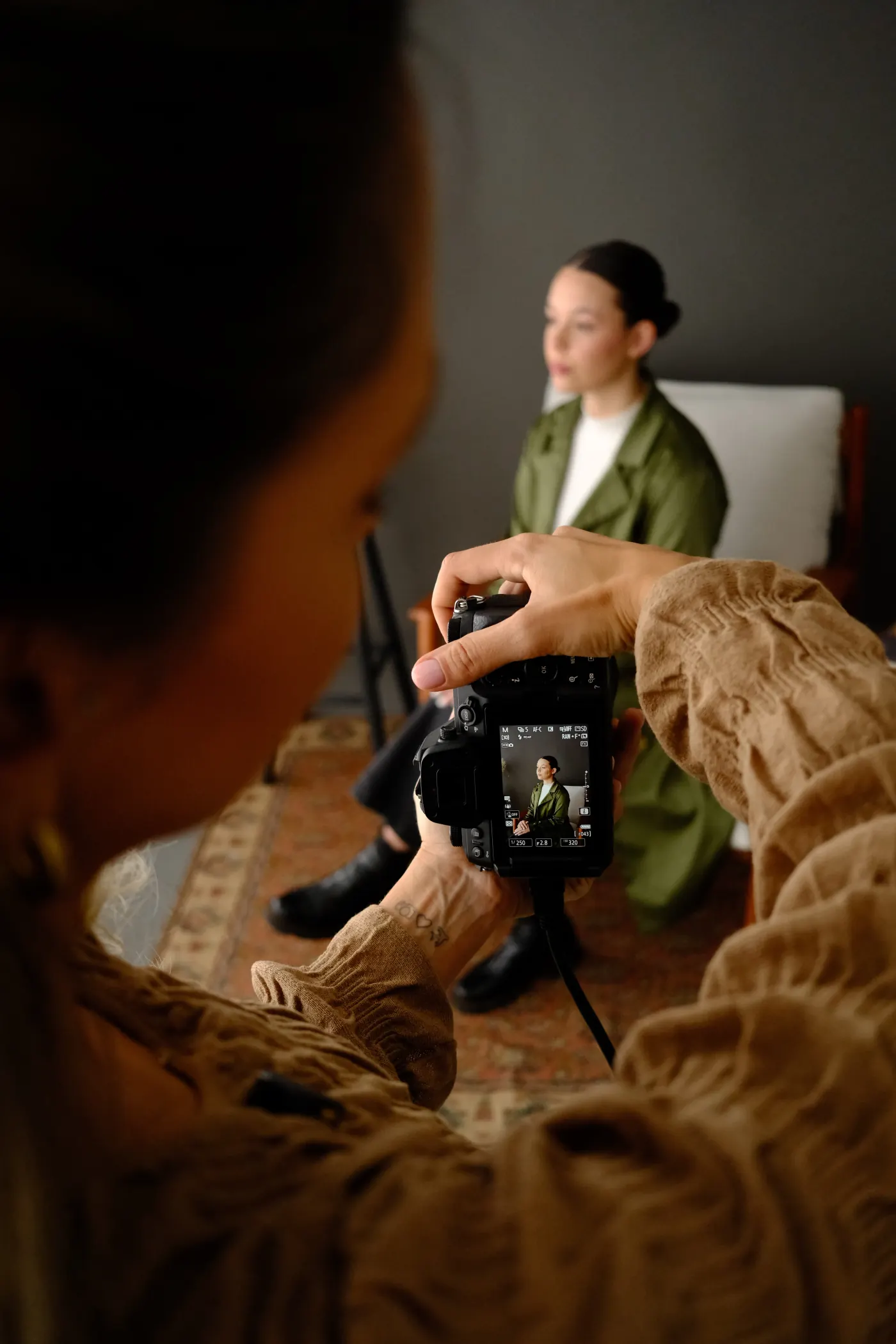 Aluna configurando câmera profissional em aula prática de fotografia de estúdio.